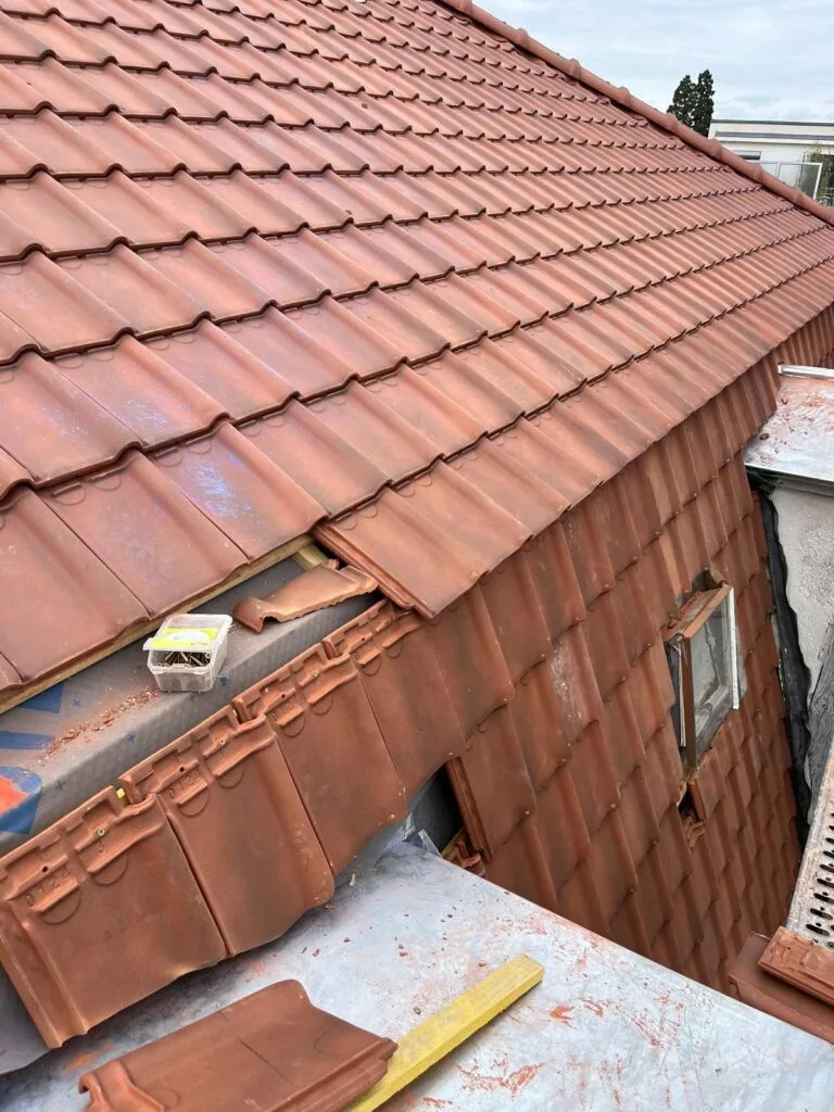 Pose de tuiles sur une toiture en rénovation